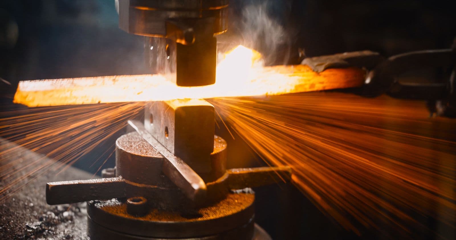 Hot forging at Aggarwal Industries' rolling and forging unit, sparks flying off freshly forged steel